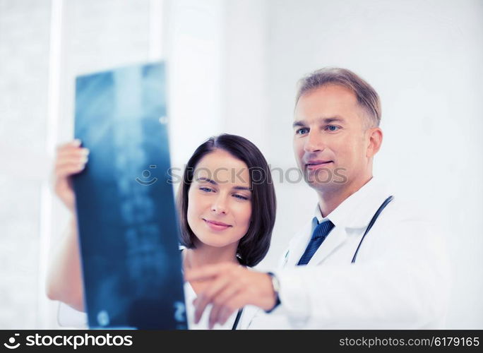 healthcare, medical and radiology concept - two doctors looking at x-ray