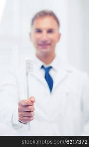 healthcare, medical and stomatology - dentist with toothbrush in hospital