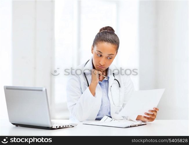 healthcare, medical and technology concept - african female doctor with laptop pc writing prescription