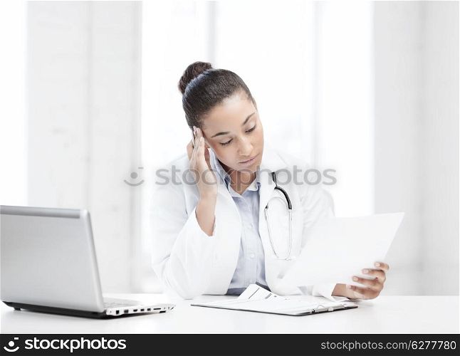 healthcare, medical and technology concept - african female doctor with laptop pc writing prescription