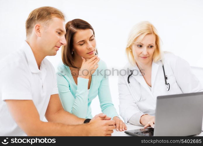 healthcare, medical and technology concept - doctor with patients looking at laptop