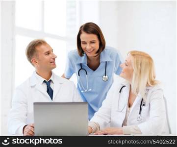 healthcare, medical and technology concept - group of doctors looking at laptop