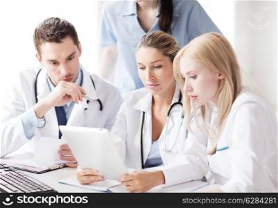 healthcare, medical and technology concept - group of doctors looking at tablet pc