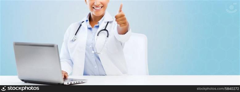 healthcare, medical and technology concept - happy african american female doctor with laptop pc computer showing thumbs up over blue background
