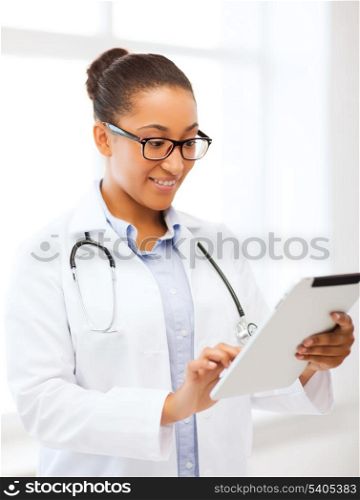 healthcare, medical and technology concept - smiling african female doctor with tablet pc in hospital