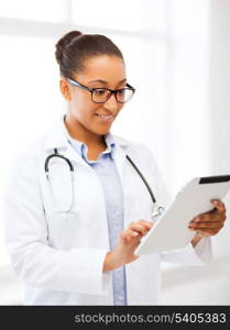 healthcare, medical and technology concept - smiling african female doctor with tablet pc in hospital