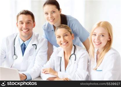 healthcare, medical and technology concept - smiling group of doctors with laptop computer in hospital