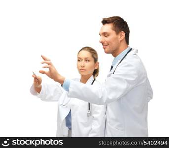 healthcare, medical and technology concept - two young doctors working with something imaginary