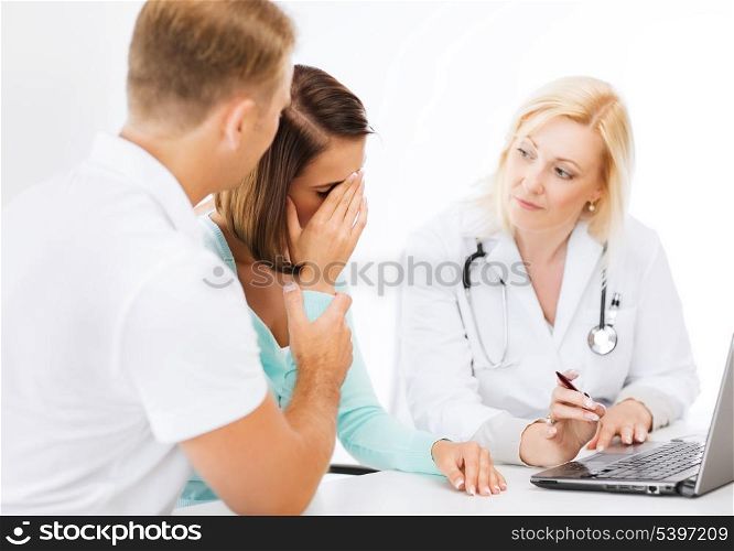 healthcare, medical and technology - doctor with patients looking at laptop