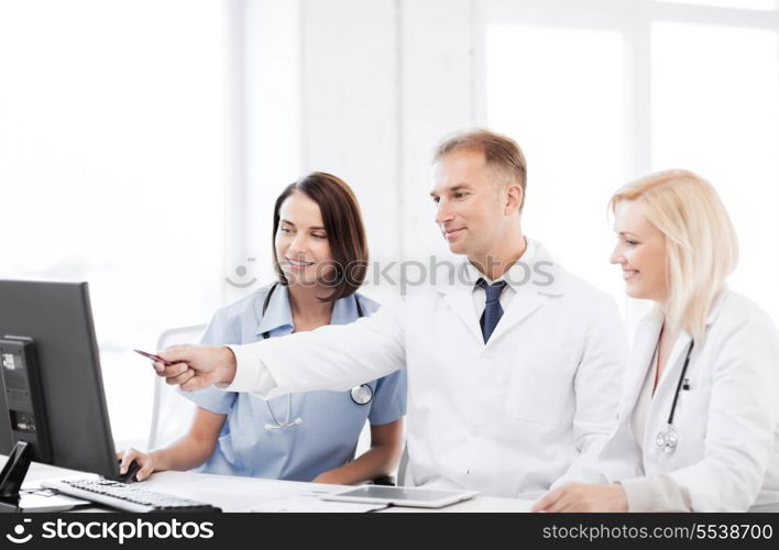 healthcare, medical and technology - group of doctors looking at computer on meeting