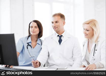 healthcare, medical and technology - group of doctors looking at computer on meeting