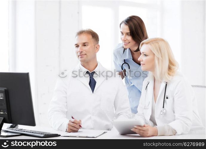 healthcare, medical and technology - group of doctors looking at computer on meeting