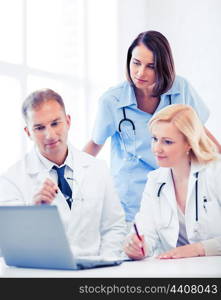 healthcare, medical and technology - group of doctors looking at laptop on meeting