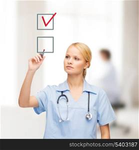 healthcare, medical and technology - young doctor or nurse with marker drawning red checkmark into checkbox