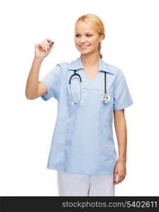 healthcare, medical and technology - young doctor or nurse writing something in the air
