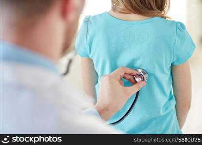 healthcare, medical exam, people, children and medicine concept - close up of girl and doctor with stethoscope listening to heartbeat