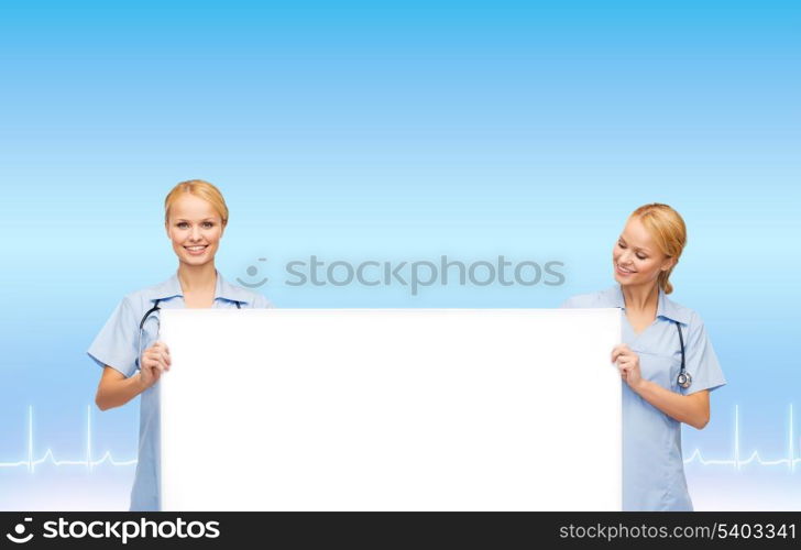 healthcare, medicine, advertisement and sale concept - smiling female doctors or nurses with stethoscope and white blank board