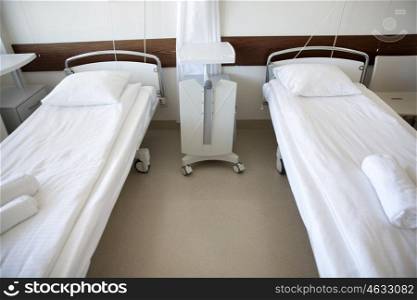 healthcare, medicine and ambulatory concept - hospital ward with clean empty beds