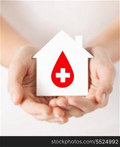 healthcare, medicine and blood donation concept - hands holding hands holding white paper house with red donor sign