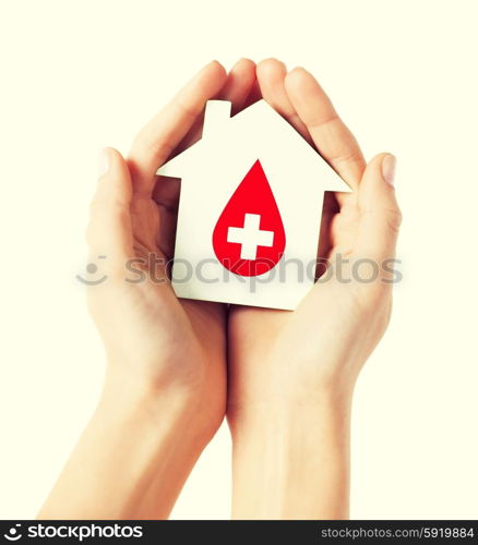 healthcare, medicine and blood donation concept - hands holding hands holding white paper house with red donor sign