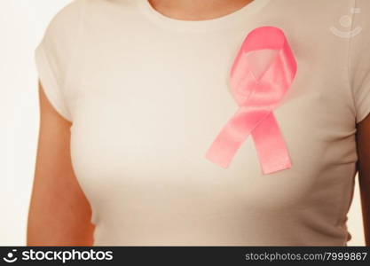 Healthcare, medicine and breast cancer awareness concept. Closeup pink cancer ribbon on woman chest