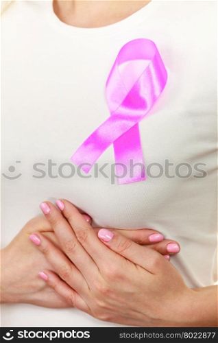 Healthcare, medicine and breast cancer awareness concept. Closeup pink cancer ribbon on woman chest