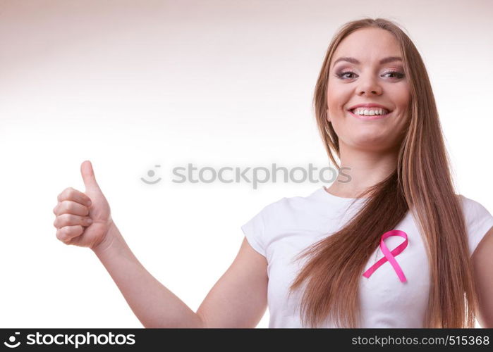 Healthcare, medicine and breast cancer awareness concept. Content young woman with pink cancer ribbon on chest making thumb up hand gesture. woman pink cancer ribbon on chest making thumb up