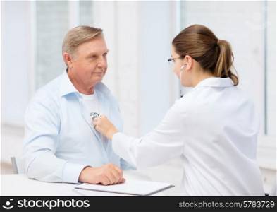 healthcare, medicine and elderly concept - female doctor or nurse with old man listening to heart beat