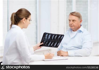 healthcare, medicine and elderly concept - female doctor with old man looking at x-ray