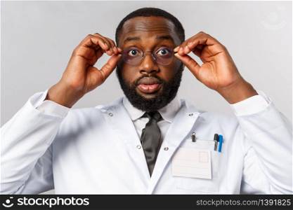 Healthcare, medicine and hospital treatment concept. Close-up portrait of shocked and impressed african-american doctor cant believe own eyes, put on glasses and stare astounded camera.. Healthcare, medicine and hospital treatment concept. Close-up portrait of shocked and impressed african-american doctor cant believe own eyes, put on glasses and stare astounded camera