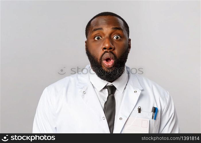 Healthcare, medicine and hospital treatment concept. Close-up portrait of shocked and speechless african-american doctor, physician gasp and startled staring camera, standing astonished.. Healthcare, medicine and hospital treatment concept. Close-up portrait of shocked and speechless african-american doctor, physician gasp and startled staring camera, standing astonished