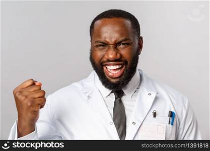 Healthcare, medicine and hospital treatment concept. Close-up portrait of triumphing, rejoicing african-american doctor finally fought disease got positive test results, fist pump and saying yes.. Healthcare, medicine and hospital treatment concept. Close-up portrait of triumphing, rejoicing african-american doctor finally fought disease got positive test results, fist pump and saying yes