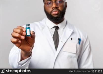 Healthcare, medicine and hospital treatment concept. Serious-looking scientist, african-american doctor in laboratory showing brand-new working vaccine from covid 19, coronavirus cure.. Healthcare, medicine and hospital treatment concept. Serious-looking scientist, african-american doctor in laboratory showing brand-new working vaccine from covid 19, coronavirus cure