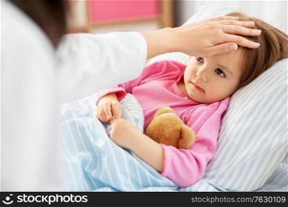 healthcare, medicine and people concept - close up of doctor measuring temperature of little sick girl lying in bed at home. doctor measuring sick girl&rsquo;s temperature at home