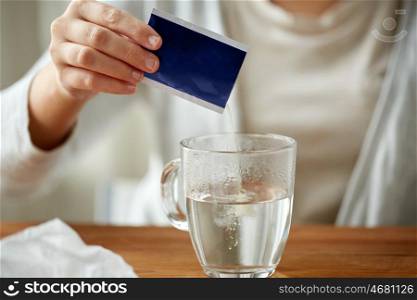 healthcare, medicine and people concept - close up of woman pouring medication into cup of water