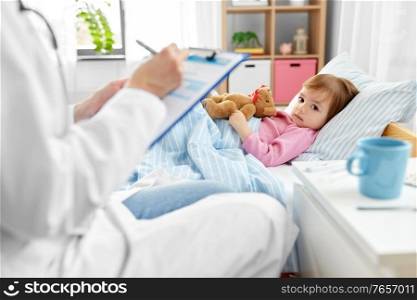 healthcare, medicine and people concept - doctor with clipboard and little sick girl lying in bed at home. doctor with clipboard and sick girl in bed at home