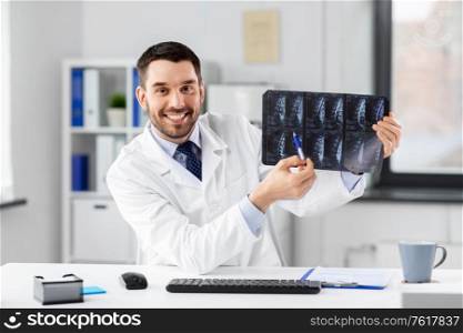 healthcare, medicine and people concept - happy smiling male doctor with x-ray scan of spine having video conference at hospital. doctor with x-ray having video call at clinic