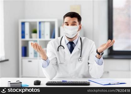 healthcare, medicine and people concept - male doctor in medical mask with stethoscope having video conference at hospital. male doctor having video conference at hospital