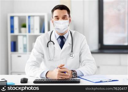 healthcare, medicine and people concept - male doctor in medical mask with stethoscope at hospital. male doctor in medical mask at hospital