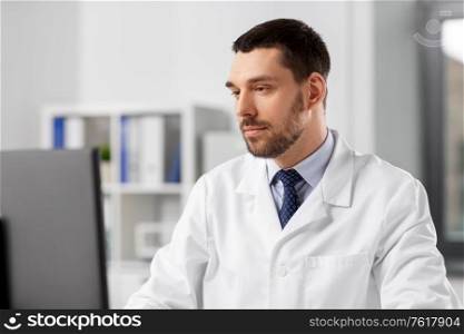 healthcare, medicine and people concept - male doctor with computer working at hospital. male doctor with computer working at hospital