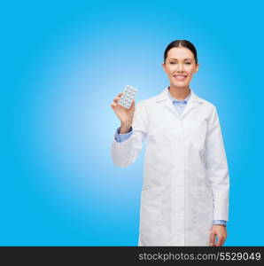 healthcare, medicine and pharmacy concept - smiling female doctor and with pills