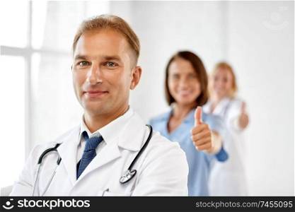 healthcare, medicine and profession concept - smiling male doctor in white coat at hospital. smiling doctor in white coat at hospital