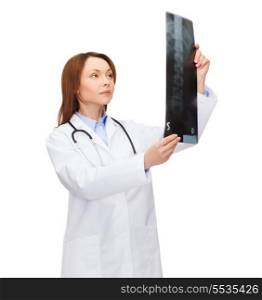 healthcare, medicine and radiology concept - serious female doctor with stethoscope looking at x-ray