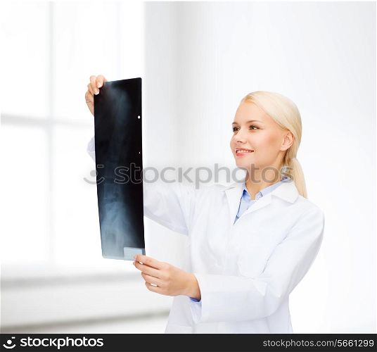healthcare, medicine and radiology concept - smiling female doctor looking at x-ray over white room background