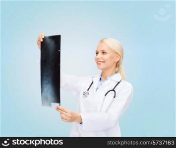 healthcare, medicine and radiology concept - smiling female doctor looking at x-ray image over blue background