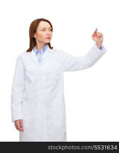 healthcare, medicine and technology concept - calm, female doctor pointing to something or pressing imaginary button