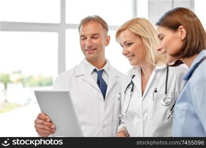 healthcare, medicine and technology concept - group of doctors with tablet computer at hospital. group of doctors with tablet computer at hospital