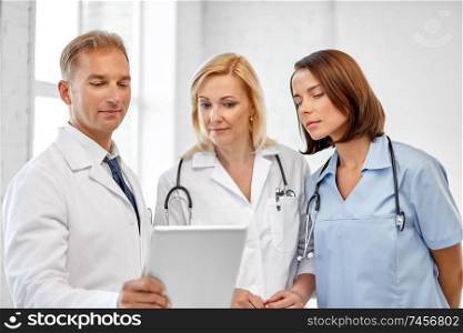 healthcare, medicine and technology concept - group of doctors with tablet computer at hospital. group of doctors with tablet computer at hospital