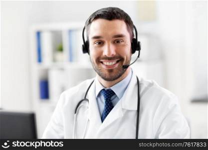 healthcare, medicine and technology concept - happy smiling male doctor with headset working at hospital. happy male doctor with headset at hospital