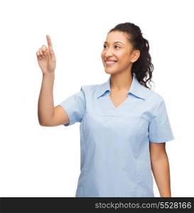 healthcare, medicine and technology concept - smiling african american doctor or nurse pointing to something or pressing imaginary button